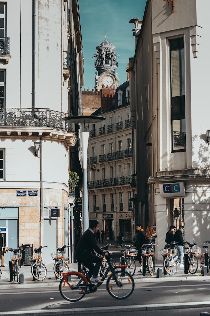 Man Riding Bicycle on Road Near Buildings